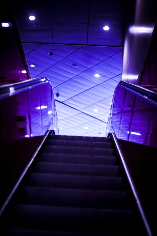an escalator going down a flight of stairs, an album cover, inspired by Zaha Hadid, light and space, ((purple)), interesting lights, mall, on ship