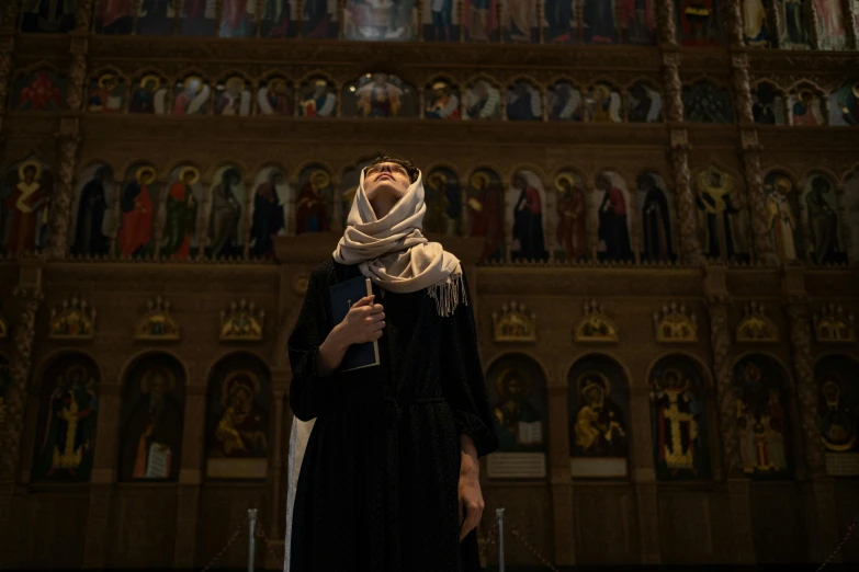 a woman in a black dress standing in front of a church, unsplash, renaissance, islamic, standing in front of the altar, as she looks up at the ceiling, [ theatrical ]