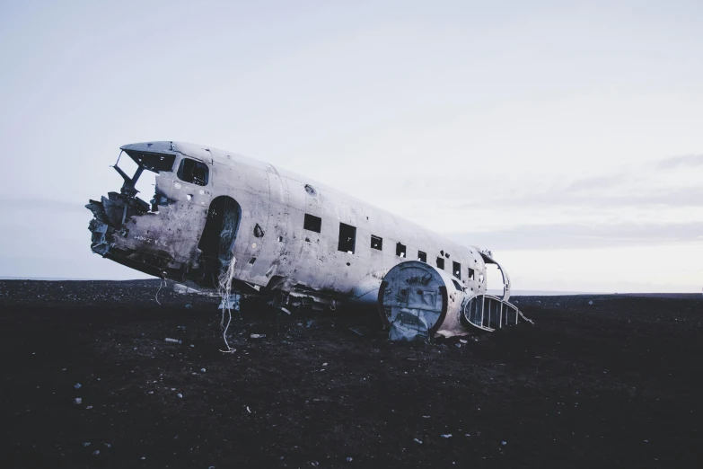 a large airplane sitting on top of a field, by Lucia Peka, unsplash contest winner, destroyed body, reykjavik, faded and dusty, moon crash into earth