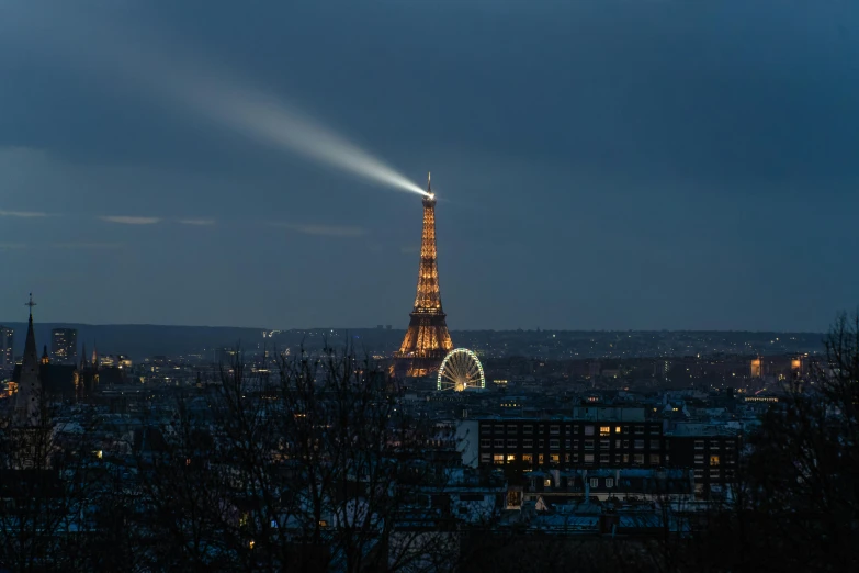 the eiffel tower is lit up at night, pexels contest winner, seen from far away, searchlight, light cone, lpoty