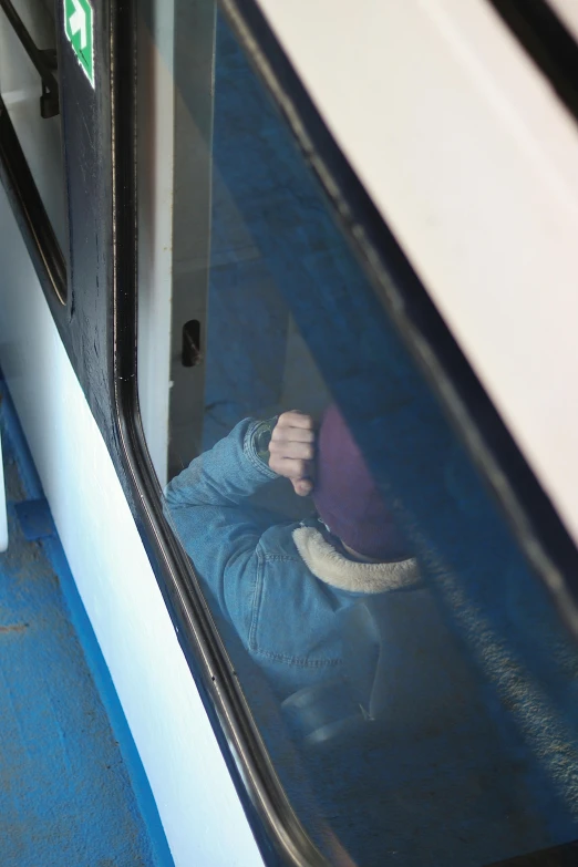 a person sitting on a bus looking out the window, inspired by Leandro Erlich, happening, face down, balaclava, thick blue lines, pointing at the camera