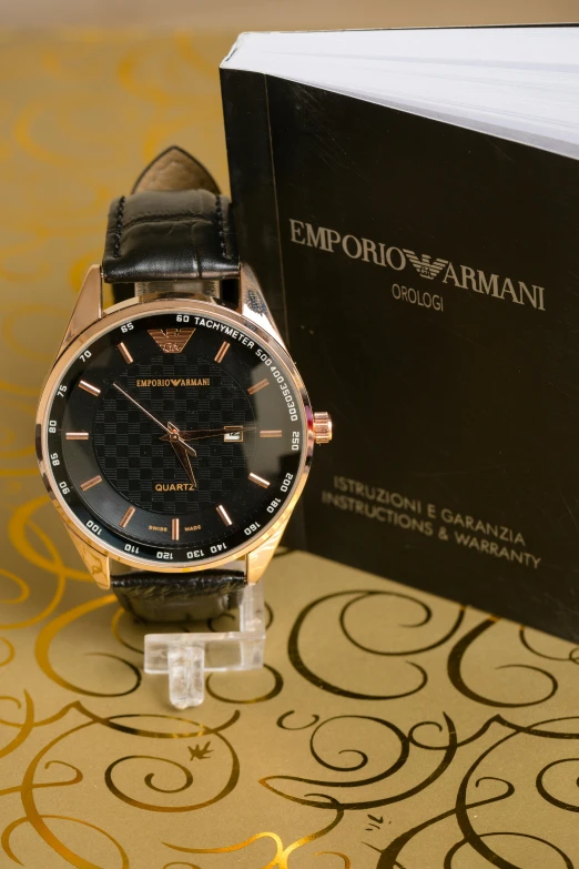 a watch sitting on top of a table next to a book, a picture, inspired by Emiliano Di Cavalcanti, armani, 2 5 6 x 2 5 6, red gold black, ebay listing thumbnail