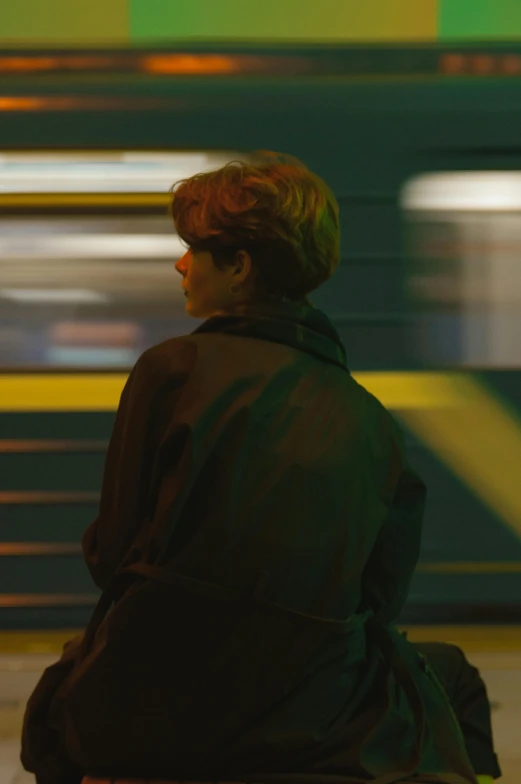 a woman sitting on a bench in front of a train, inspired by Nan Goldin, sophia lillis, worksafe. cinematic, with his back to the viewer, yellow lights