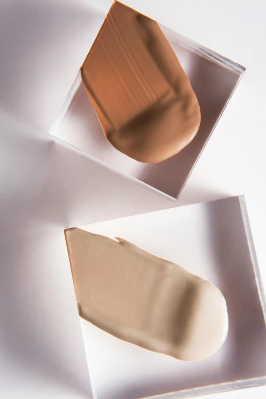 a couple of boxes sitting on top of a table, perfect skin tones, foundation, muted tonal colors, sinuous