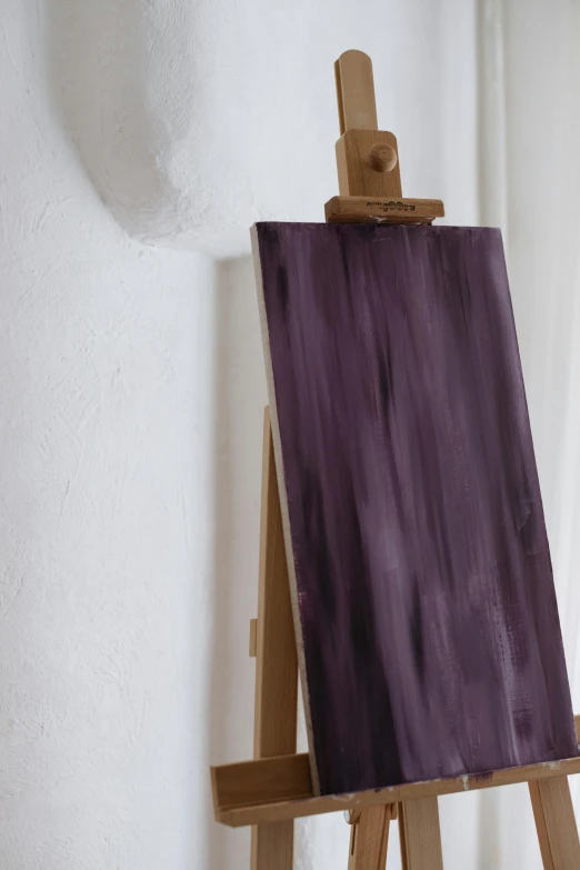 a close up of an easel with a painting on it, inspired by Andrea del Sarto, trending on pexels, abstract art, made of liquid purple metal, rustic, moderate colors, black chalk