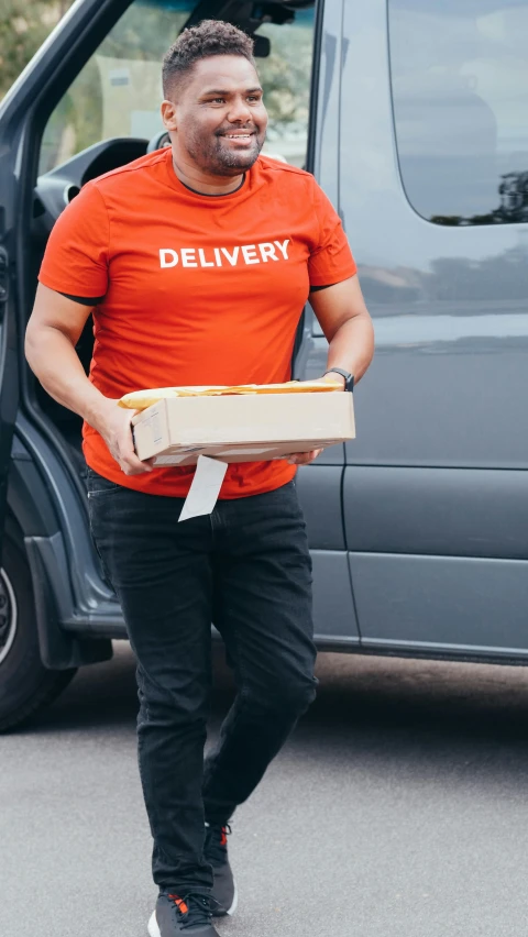 a man in an orange shirt carrying a pizza box, pexels contest winner, hurufiyya, drive out, low quality photo, square, black