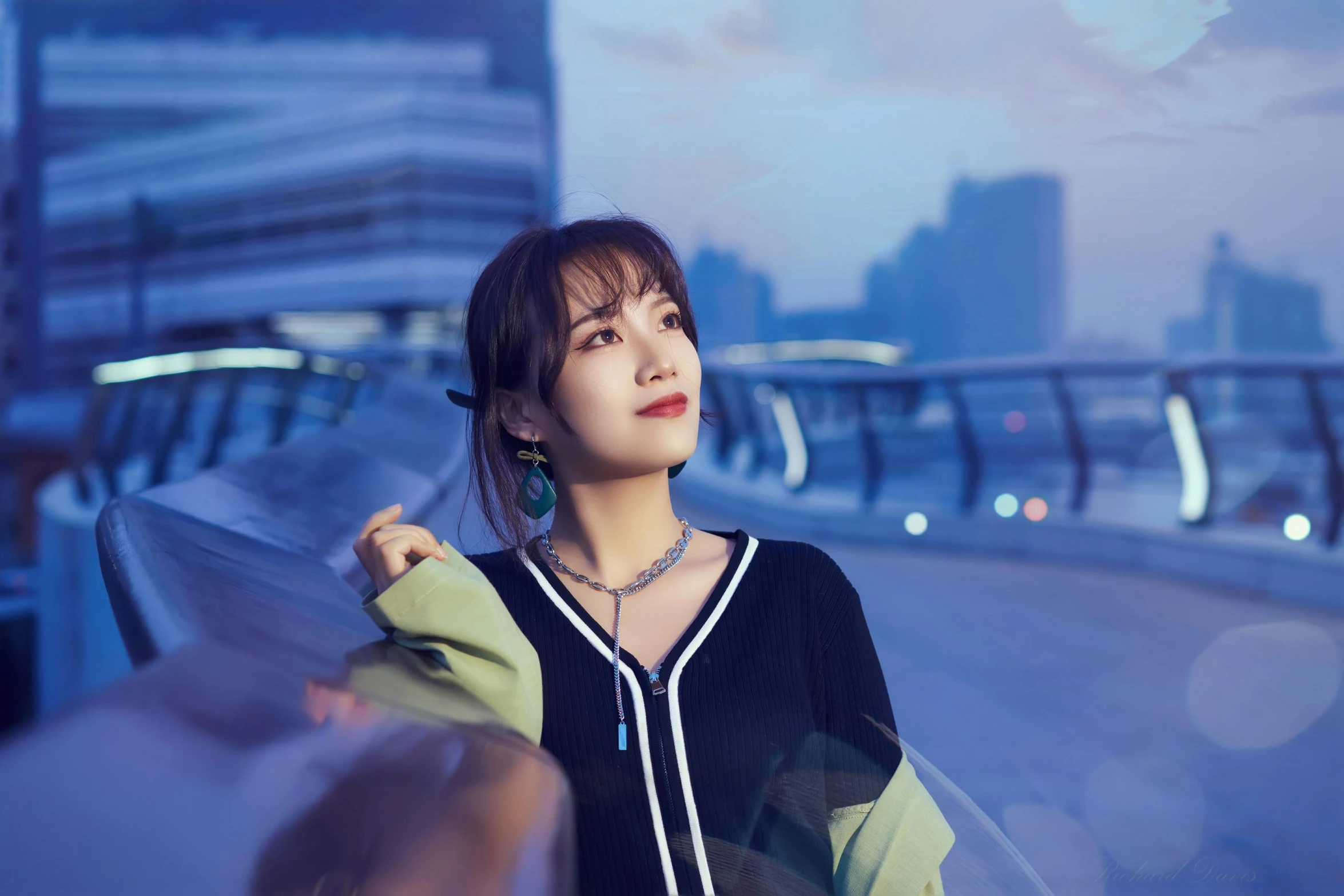 a woman standing on a bridge with a city in the background, a picture, inspired by Huang Ji, unsplash, realism, cute korean actress, 🤤 girl portrait, dazzling lights, jewelry