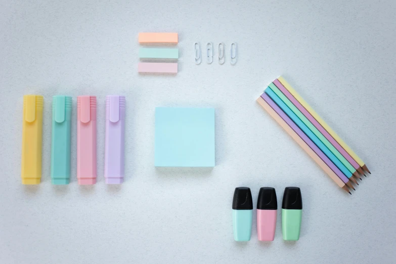 a white table topped with lots of different colored pencils, inspired by Yanjun Cheng, trending on pexels, minimalism, pastel blue, various items, mint, on a gray background