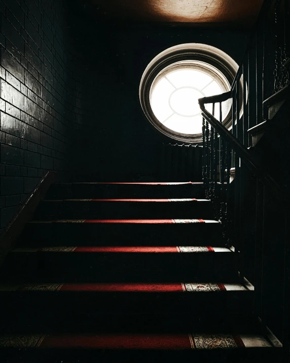 a set of stairs leading up to a round window, inspired by Gertrude Abercrombie, pexels contest winner, gothic lighting, window light, haunted gothic hotel, instagram photo