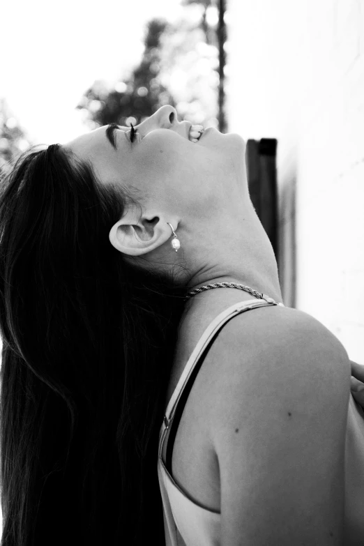 a black and white photo of a woman with long hair, by Caro Niederer, unsplash, happening, earing a shirt laughing, pierced navel, profile image, girl with a pearl earringl