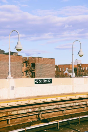 a train on the tracks at a train station, inspired by Washington Allston, trending on unsplash, street signs, brooklyn, panoramic, gas lamps