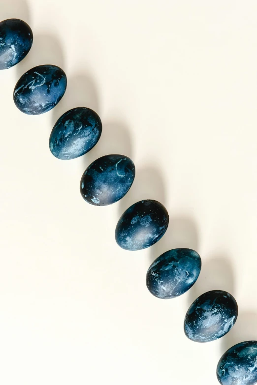 a strand of blue marble beads on a white surface, unsplash, bauhaus, jewelry engraved in scarab, thumbnail, grape, full frame image
