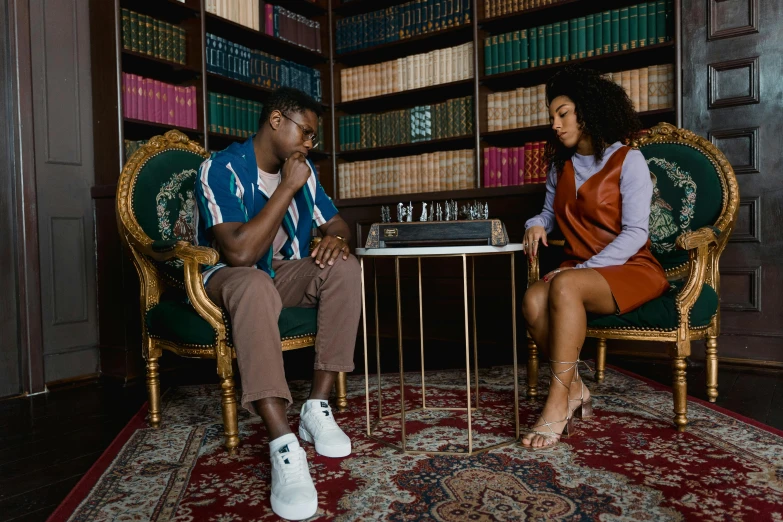 a man and a woman sitting at a table in a library, an album cover, by Carey Morris, trending on pexels, black arts movement, giant marble chess pieces, cinematic outfit photo, focus on sneakers only, tv still