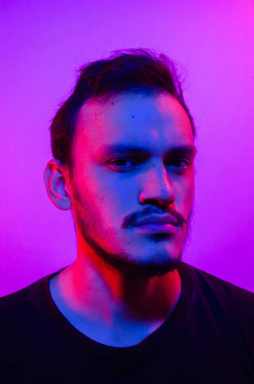 a man standing in front of a purple light, an album cover, inspired by Camilo Egas, antipodeans, looking intensely at the camera, discord profile picture, profile image, bisexual lighting