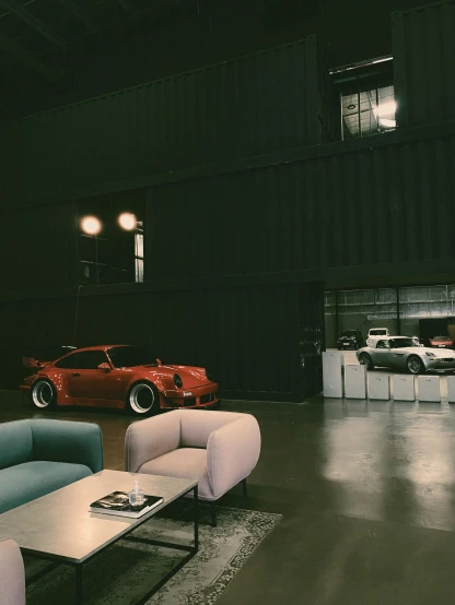 a living room filled with furniture and a red sports car, a colorized photo, unsplash, hangar, lo fi, thicc build, ready for a meeting