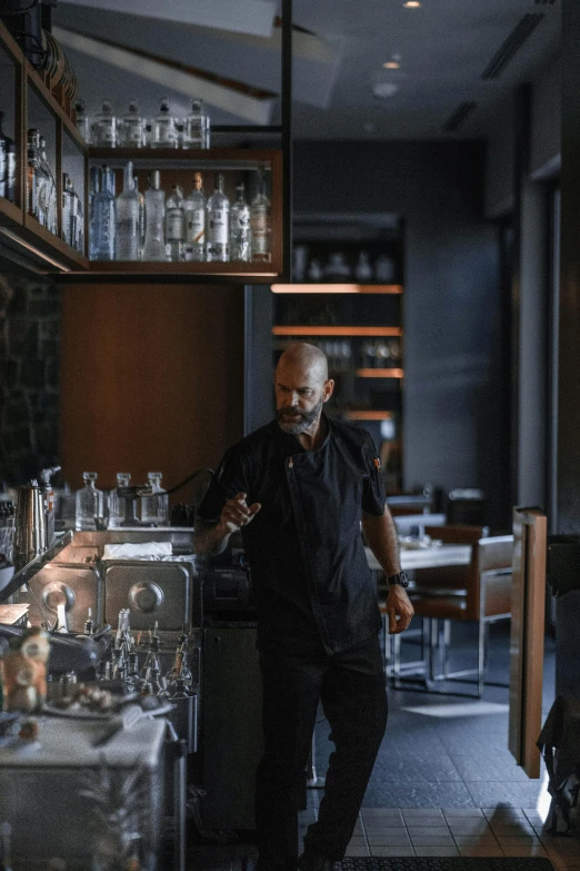 a man standing in front of a counter in a restaurant, a portrait, by Mathias Kollros, unsplash, 💣 💥💣 💥, cinematic still in westworld, walking towards camera, smoking