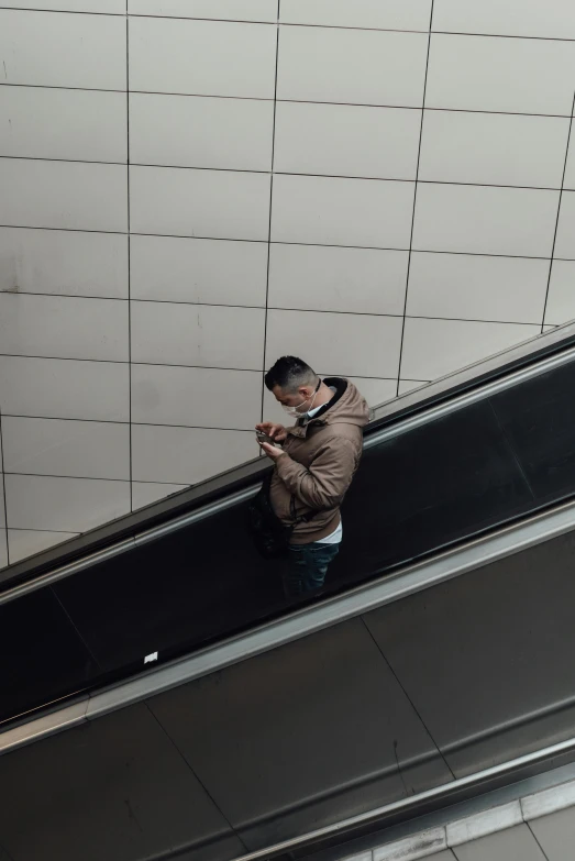 a man taking a picture of himself on an escalator, trending on pexels, lonely human walking, brown, professional iphone photo, asian male