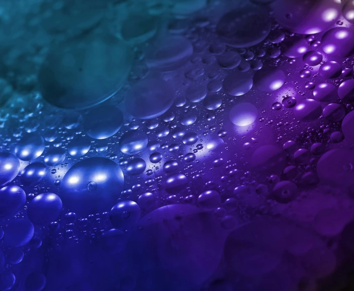 a close up of water bubbles on a purple and blue background, by Adam Marczyński, pexels, digital art, background image, intricate macro closeup, lights on, made of oil and water