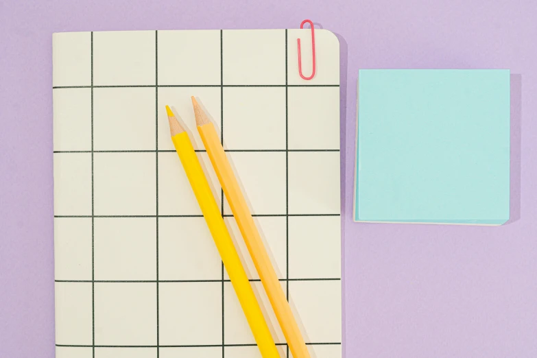 two yellow pencils sitting on top of a piece of paper, trending on pexels, purple checkerboard, neon pastel color palette, squares, notebook