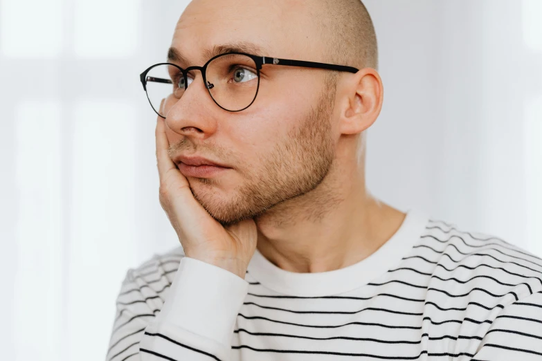 a man with a bald head wearing glasses, inspired by Leo Leuppi, trending on pexels, hyperrealism, square rimmed glasses, thoughtful ), thin young male, androgynous person