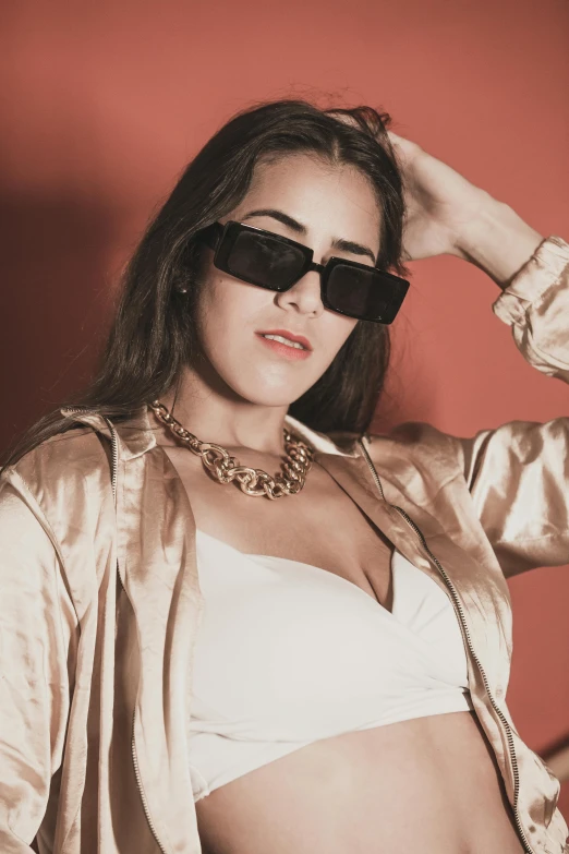 a woman wearing sunglasses is posing for a picture, an album cover, inspired by Elsa Bleda, trending on pexels, thick collar, latinas, rectangle, gold clothes