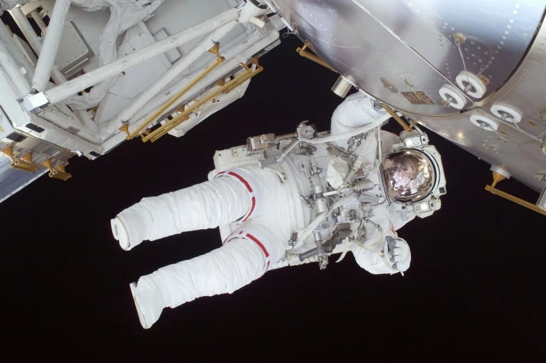 an astronaut in a spacesuit in front of a space station, photograph, bottom angle, high angle shot, taken in the 2000s