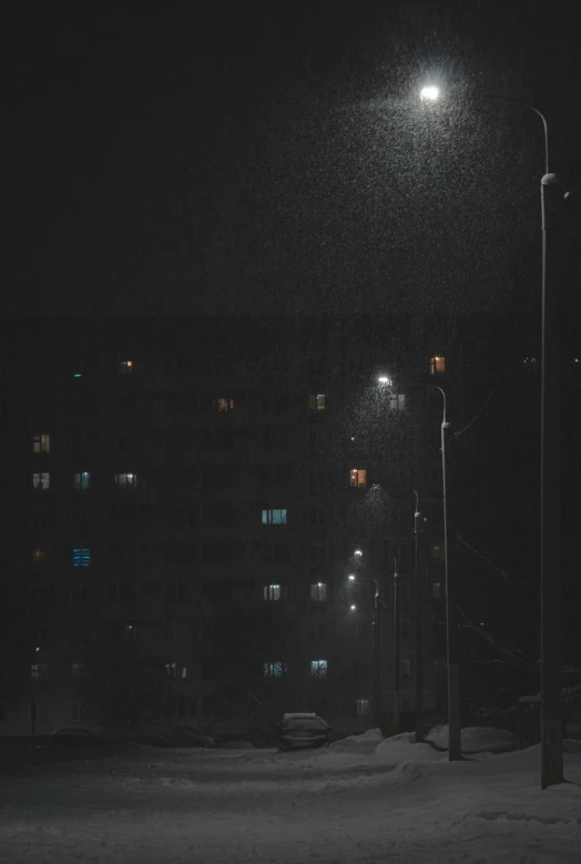 a black and white photo of a street at night, a picture, inspired by Elsa Bleda, conceptual art, sleet, buildings, color photo, atmospheric lighting - n 9