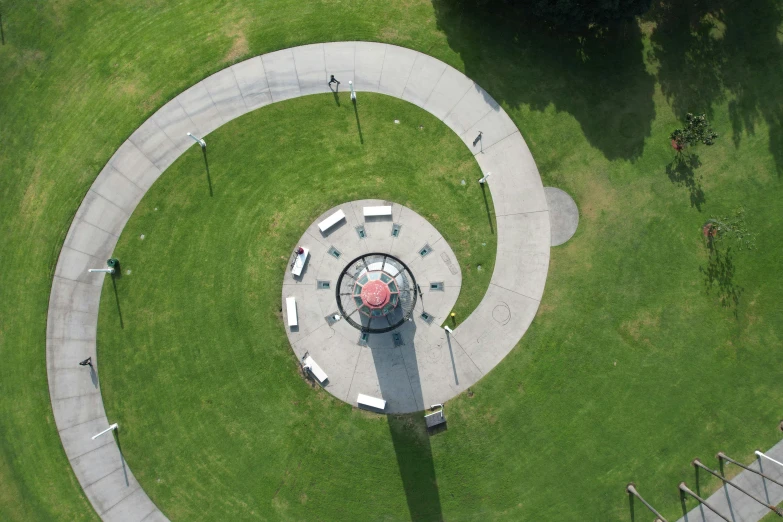 an aerial view of a park with benches and a clock, pulled into the spiral vortex, paisley, concrete poetry, camera obscura