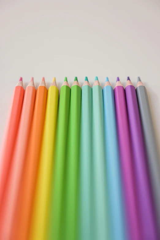 a row of colored pencils sitting on top of a table, a color pencil sketch, by Rachel Reckitt, pexels, pastel neon colors, line art colouring page, set against a white background, pearlescent hues