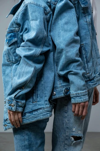 a woman wearing a denim jacket and ripped jeans, an album cover, inspired by Elsa Bleda, trending on pexels, hyperrealism, close-up product photo, background image, androgynous person, close together