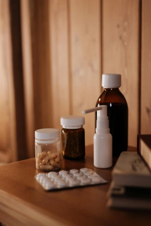 medicine bottles sitting on top of a wooden table, a picture, unsplash, multiple stories, brown, album, hotel room