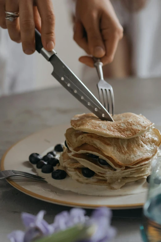 a person cutting a stack of pancakes with a knife and fork, trending on pexels, renaissance, blueberry, sculpted, flawless structure, grey