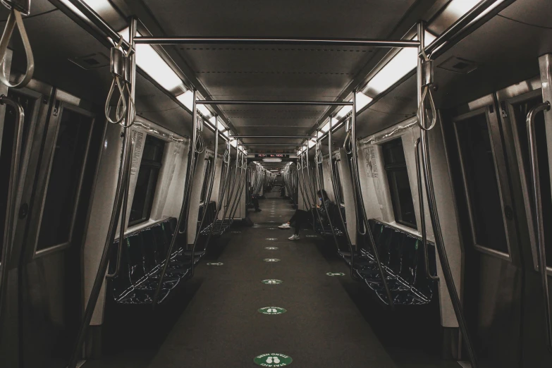 a black and white photo of a subway car, by Emma Andijewska, unsplash contest winner, very dark with green lights, in the middle of an empty room, in a row, non-binary