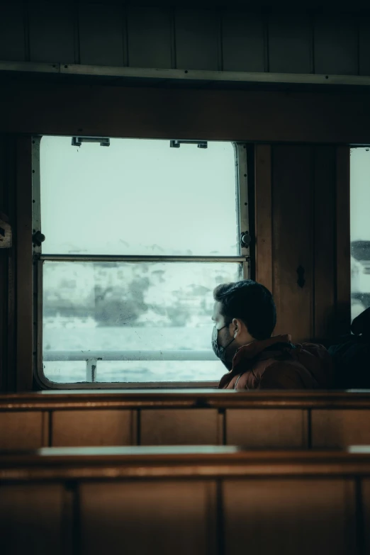 a person sitting in a train looking out a window, on a boat, man with thin lines on the face, unsplash photography, 🚿🗝📝