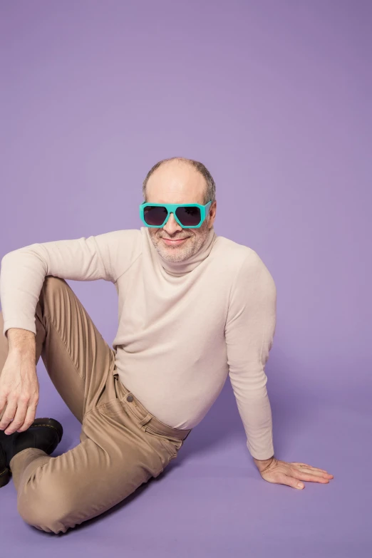 a man sitting on the ground wearing sunglasses, inspired by Leo Leuppi, superflat, teal studio backdrop, ((purple)), balding, wearing turtleneck