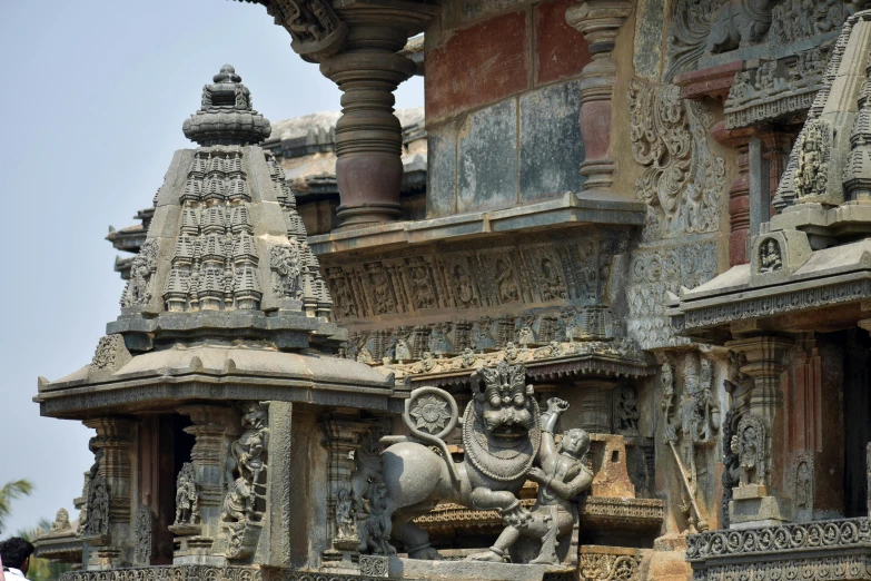 a couple of people that are standing in front of a building, a statue, samikshavad, elaborate carved wood balconies, viewed from a distance, intricate details photograph, image