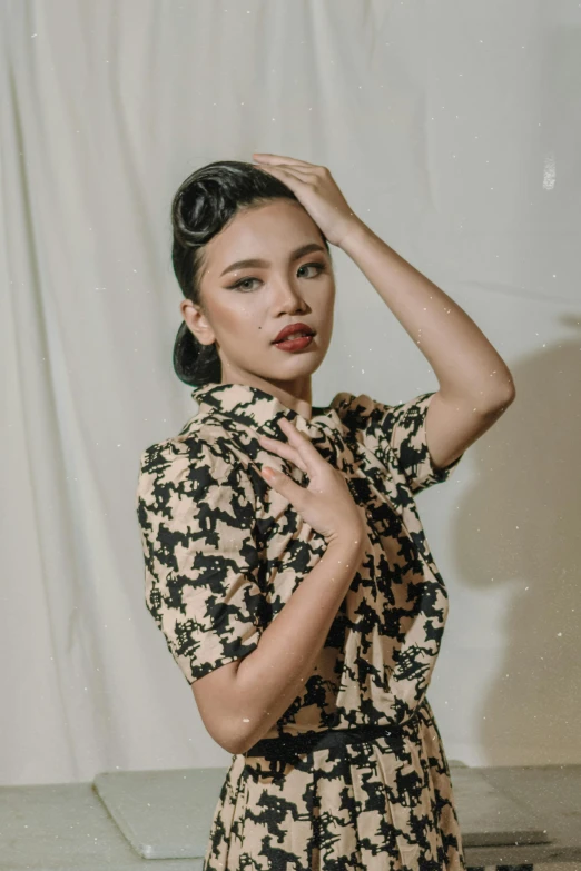 a woman standing in front of a white backdrop, an album cover, inspired by Ruth Jên, patterned clothing, 1 9 4 0 s haircut, promo image, at a fashion shoot