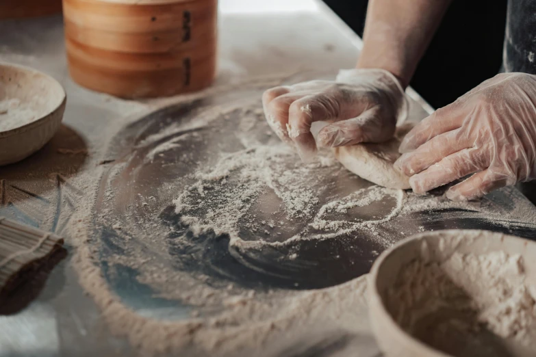 a person kneads a dough on a table, by Julia Pishtar, trending on pexels, process art, traditional chinese, sand swirling, thumbnail, pastry