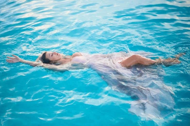 a woman in a white dress floating in a pool, profile image, fan favorite, dolphin swimming, translucent dress