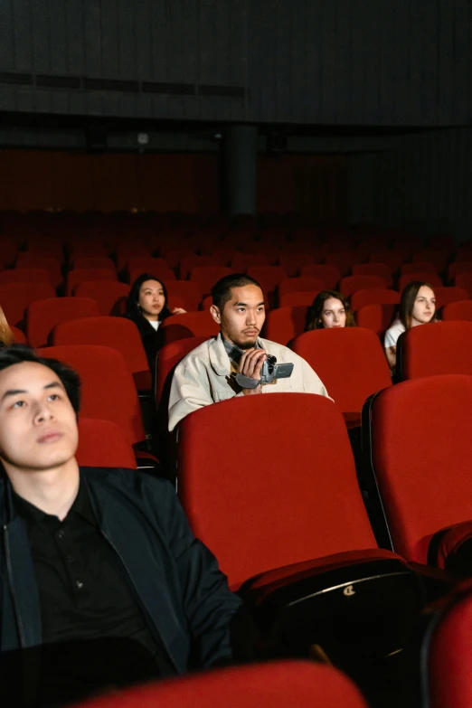 a group of people sitting in a movie theater, inspired by Fei Danxu, hyperrealism, [ theatrical ], gen z, cinestill 800t 35mm eastmancolor, 278122496