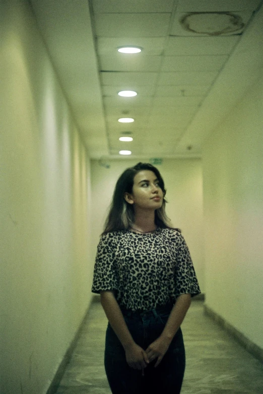 a woman standing in the middle of a hallway, inspired by Elsa Bleda, unsplash, serial art, portrait of priyanka chopra, around 1 9 years old, concert, scanned