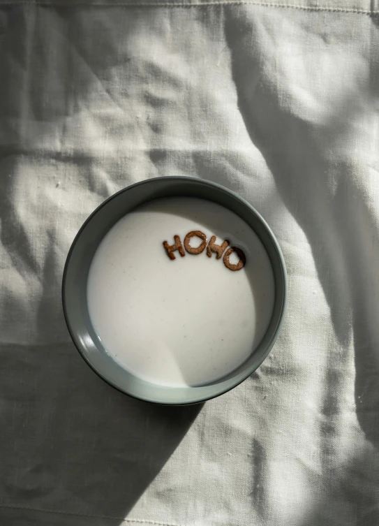 a cup of milk sitting on top of a bed, by Valentine Hugo, trending on unsplash, holography, halo halo halo halo 8k, hidden message, high angle close up shot, zen aesthetic