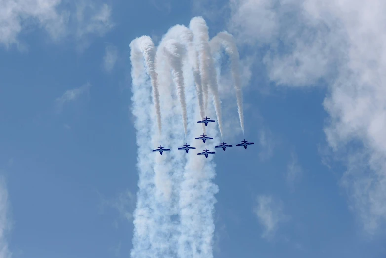 a group of airplanes flying through a blue sky, a photo, by Lee Loughridge, pexels contest winner, hurufiyya, smokey cannons, avatar image, reds, blue and white