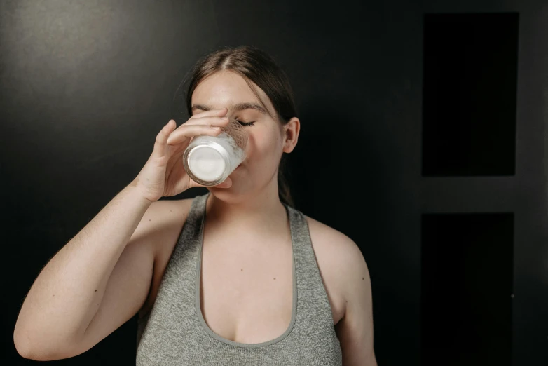 a woman in a tank top drinking from a bottle, pexels contest winner, aussie baristas, avatar image, milk, profile image