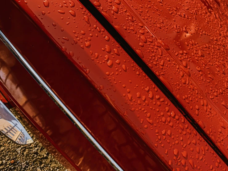 a close up of a red car with water on it, red ocher, thumbnail, coated pleats, with a sleek spoiler