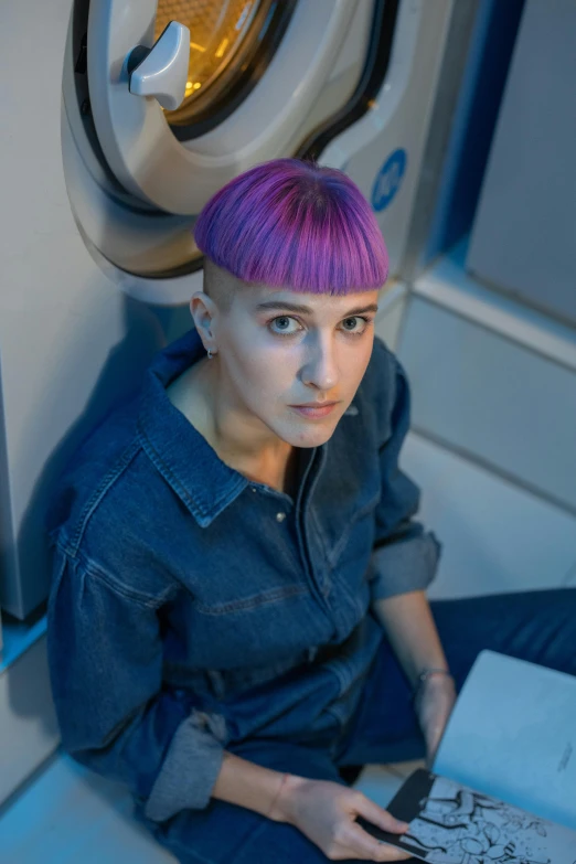 a woman sitting on a train reading a book, by Harriet Zeitlin, short purple hair with undercut, stood in a lab, in a space station, headshot profile picture