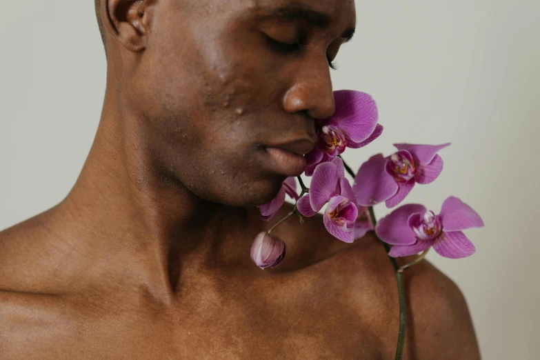 a man with a flower in his mouth, inspired by Robert Mapplethorpe, trending on pexels, brown skin, overgrown with orchids, male body, making out
