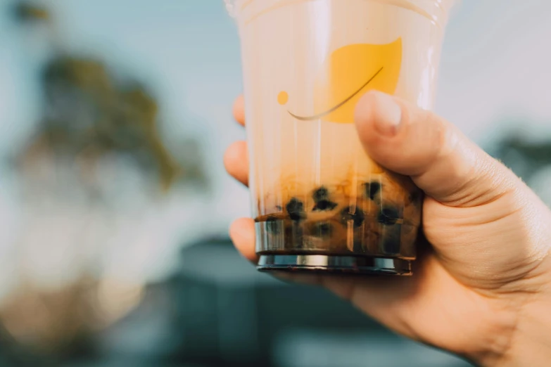a person holding a drink in a plastic cup, trending on pexels, holding a boba milky oolong tea, yellow lanterns, avatar image, fruit