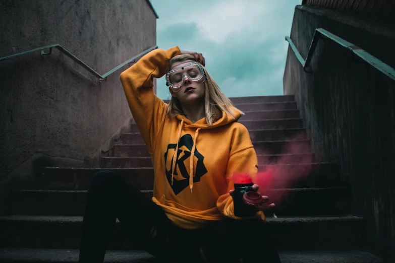 a woman in a yellow hoodie holding a spray bottle, inspired by Elsa Bleda, trending on pexels, graffiti, cyberpunk eye wear, sitting on temple stairs, avatar image, amouranth