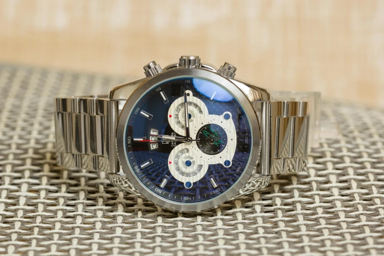 a close up of a watch on a table, pexels contest winner, hurufiyya, silver and blue colors, highly detailed-h 704, demur, monaco